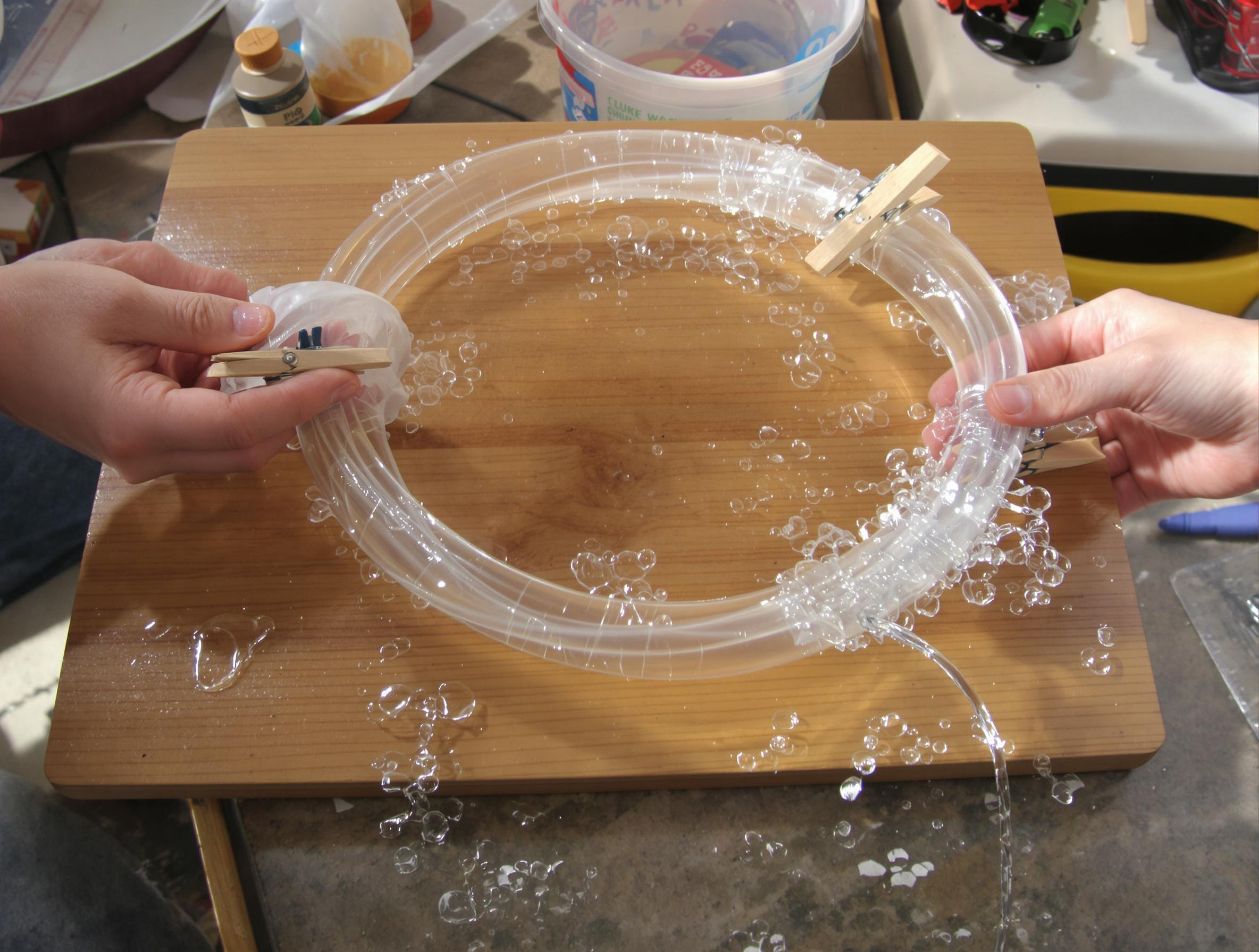 Montage d’une pompe péristaltique DIY avec tube silicone et pinces à linge.