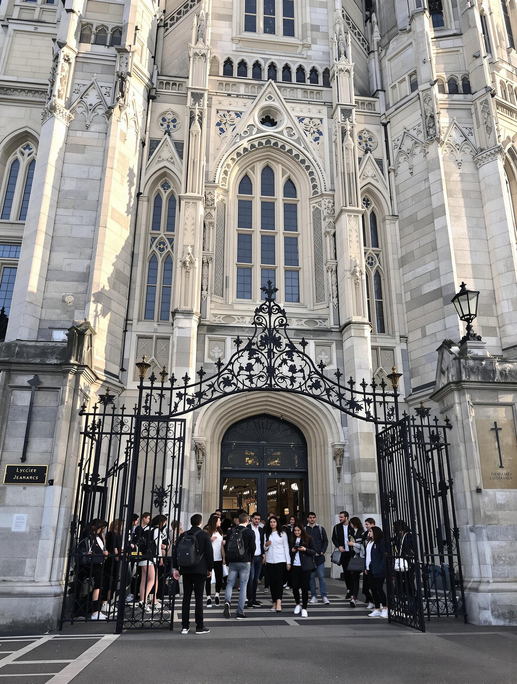 Façade néogothique du Lycée Jeanne d’Arc à Caen un matin de rentrée ; élèves en uniforme partiel franchissant le portail