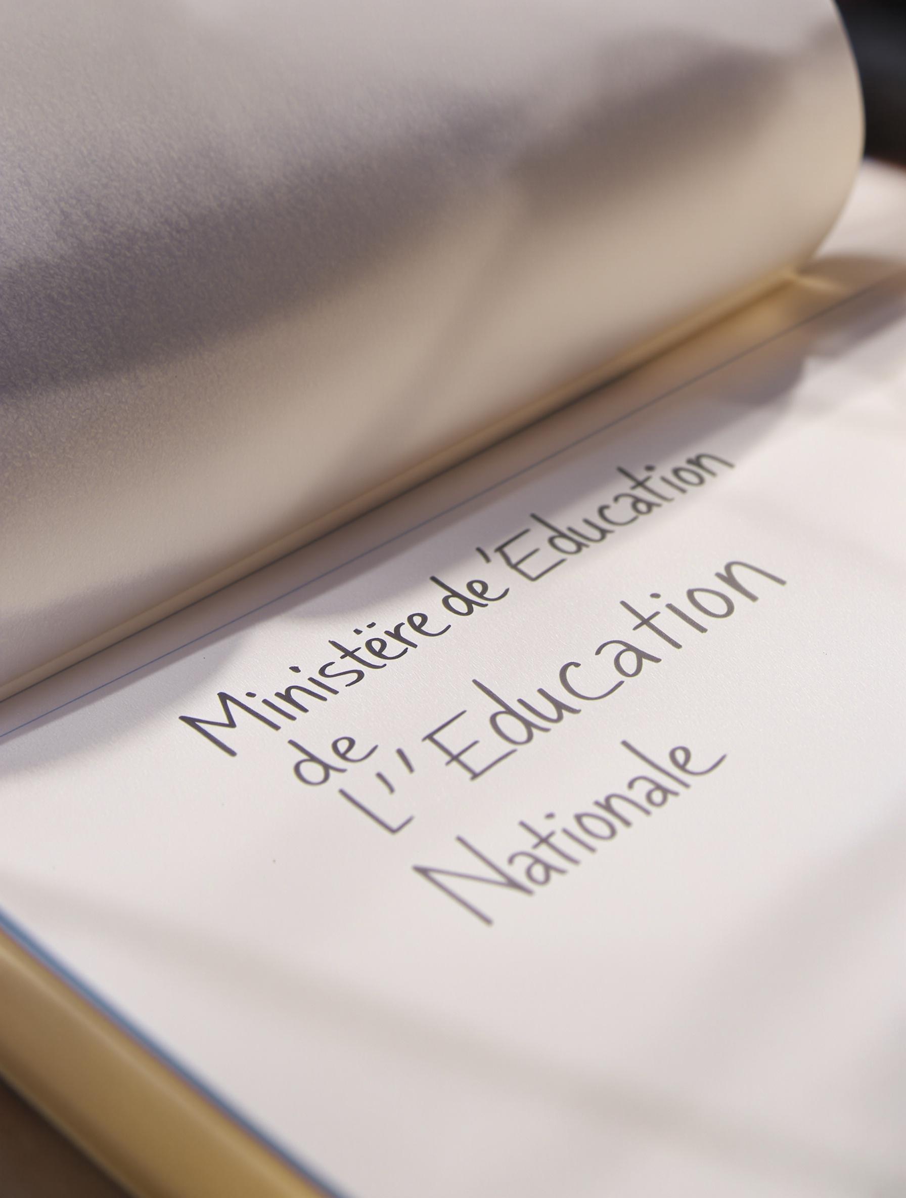 Photo en gros plan d’un cahier de correspondance d’élève avec un stylo posé dessus.